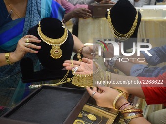 An Indian woman buying Gold jewellery in a shop during the Diwali festival called Dhanteras in Kolkata , India  on  Tuesday , 17th October ,...