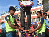Indian traditional drum troupe, their instruments decorated with feathers, busk outside Sealdah railway station as they wait to be hired for...