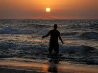 A Palestinian fisherman throws his fishing net oA Palestinian fisherman throws his fishing net on a beach in the Gaza City, October 18, 2017...