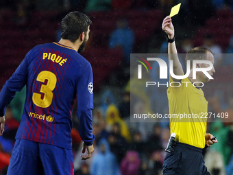 the referee William Collum shows yellow card to Gerard Pique during Champions League match between FC Barcelona v Olympiakos FC , in Barcelo...