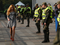 A woman passes the line of National guard line in front of Ukrainian Parliament in Kyiv, Ukraine, Oct.19, 2017. Dozens Ukrainians set up a t...