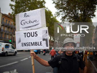 A man poses for a picture with a placard reading 'Strike ! All together'. Nearly 3000 protesters took to the streets of Toulouse, France, on...
