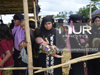 Rohingya refugees wait in lines to collect relief aid at Mowsuni in Teknaf, Bangladesh, on October 17, 2017. Some 582,000 Rohingya refugees...