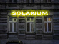 Neon letters advertising a tanning salon in the center of the city are seen on 19 October, 2017. (