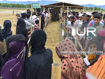 Rohingya refugees wait in lines to collect relief aid at Mowsuni in Teknaf, Bangladesh, on October 17, 2017. Some 582,000 Rohingya refugees...