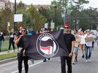 (171018) -- Gainesville, October 18, 2017 -- Anti-fascists carry a flag in front of protesters at the University of Florida in Gainesville,...