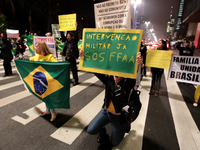 Right-wing nationalists hold Brazilian flags and a sign that says 