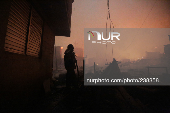 A firefighter tries to contain a major fire that hit a slum located in the Campo Belo neighborhood on the Journalista Roberto Marinho Avenue...
