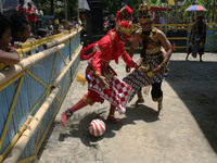Javanese people a scramble the ball during a football game using dance costume reog in Yogyakarta, Indonesia, 14 September 2014. This event...