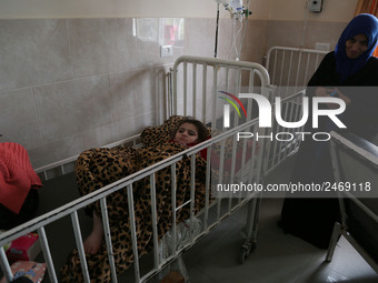 A sick Palestinian girl is held by her mother inside a room at the Durra hospital in Gaza City, February 8, 2018(