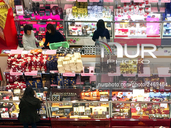 Japanese women look at chocolates displayed at a department store ahead of Valentine's Day in Tokyo February 8, 2018. (