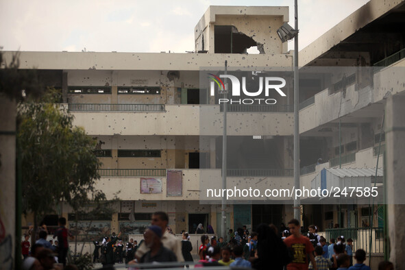 Palestinian students walk to their classrooms in their school that witnesses said was shelled by Israel during its offensive, on the The sec...