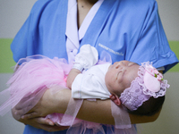 A member of nursing staff of Paolo memorial hospital holds a newborn in Valentine's Day Hearted Costume in Bangkok, Thailand, February 12, 2...