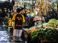 Filipinos shopping for goods in spite of being submerged in flood water caused by tropical storm Fung Wong inside a wet and dry market in Ma...