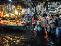 Filipinos shop for goods in spite of being submerged in flood water caused by tropical storm Fung Wong inside a wet and dry market in Manila...