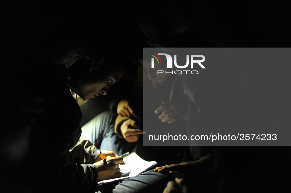 Nepalese Youths using mobile phones as lining in the night to pay the amount for the application submission for the Korean Language Test (KL...