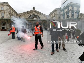 Employee of the French state owned railway company SNCF holds a flare during a demonstration in front of the Gare de l’Est train station on...