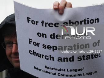 Member of Spartacist League holds 'For free abortion on demande! For separation of church and state!' sign as he joins hundreds of people in...