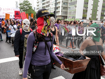 Women with masks hold a coffin symbolizing women who die from abortions that are conducted clandestinely and unsafety during a demonstration...