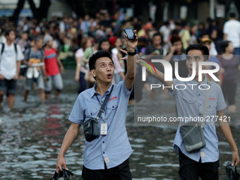 Makati, Philippines - A man has a selfie while wading though the flood in Makati City on October 7, 2014. Strong rains causing floods hamper...