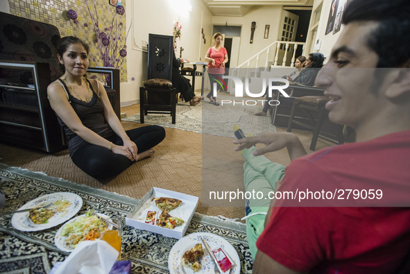 Family of Parsa, science student, eat pizza on the dinner with their relatives, as in most traditional Iranian houses, on the floor, Isfahan...