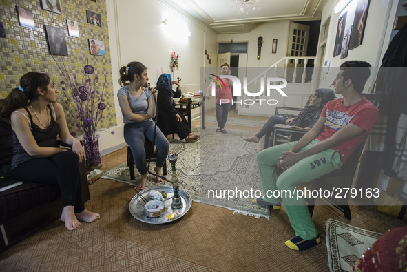 Cousins of Parsa, science student, smoke qelyan after dinner, traditional kind of entertainment in Iranian families, while his aunt Fara spe...