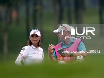 Na Yeon Choi of South Korea gets advice from her caddie before taking her second shot on the fairway of the eighteenth hole during the third...