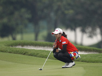 Pornanong Phatlum of Thailand lines up for a putt on the green of hole nine during the fourth round of the LPGA Malaysia golf tournament at...