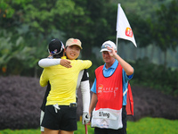 Shanshan Feng of China, centre, is congratulated by So Yeon Ryu of South Korea, left, while on the green of the eighteenth hole during the f...