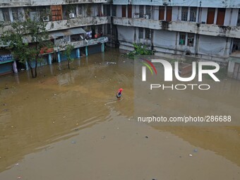 A Naga resident wade through flood water after heavy rain in Dimapur, India north eatern state of Nagaland on Sunday, October 12, 2014. Hund...