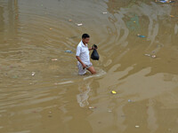 A Naga resident wade through flood water after heavy rain in Dimapur, India north eatern state of Nagaland on Sunday, October 12, 2014. Hund...