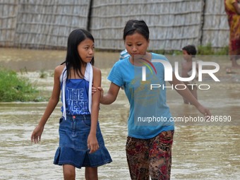 Naga residents wade through flood water after heavy rain in Dimapur, India north eatern state of Nagaland on Sunday, October 12, 2014. Hundr...