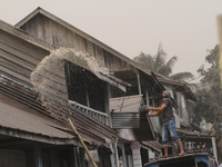 A resident of watering their roofs with thick volcanic ash cloud blowing giant black lava after the latest eruption in Karo District, Sumatr...