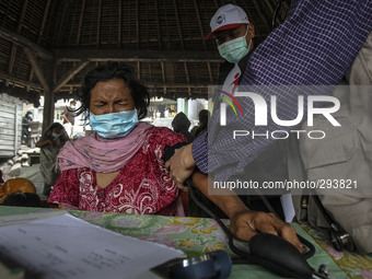 A medic health check a villager at Mardingding Village in Karo district, North Sumatra in Indonesia on October 13, 2014. The volcano, which...