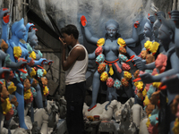 Artisans in Kumartuli- a traditionally potters quarter in northern Kolkata in India busy making Goddess Kali a Hindu deity known for her pow...