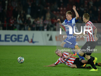 Ruch Chorzów's Eduards Visnakovs (Blue) in action, challenged by Cracovia's Adam Marciniak (Down) and Bartosz Rymaniak (Right), during the 1...