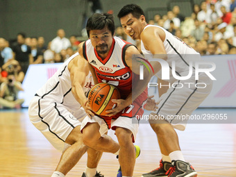 Bocaue, Bulacan Philippines - Manny Pacquiao of Kia (C) goes past Alex Nuyles (L) and Larry Rodriguez (R) of Blackwater on the 40th season o...