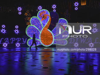 A woman pass by a large peacock decoration inconjuntion Happy Diwali at Subang Jaya,20km from Kuala Lumpur on October 20, 2014.  Diwali is a...
