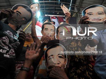 SURAKARTA, INDONESIA - October 20 : Residents carrying a mask of Indonesian new president, Joko Widodo during a celebration of the inaugurat...