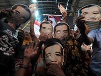 SURAKARTA, INDONESIA - October 20 : Residents carrying a mask of Indonesian new president, Joko Widodo during a celebration of the inaugurat...