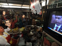 SURAKARTA, INDONESIA - October 20 : Residents carrying a mask of Indonesian new president, Joko Widodo and watch the live broadcast during a...