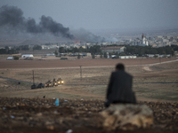 A man watches US airstrikes aimed at IS forces from a hill in Sanliurfa province of Turkey on the Syrian border on October 24, 2014.  YPG Ku...