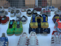 A pair of Adidas rollerskates within a collection of varied Adidas trainers. (