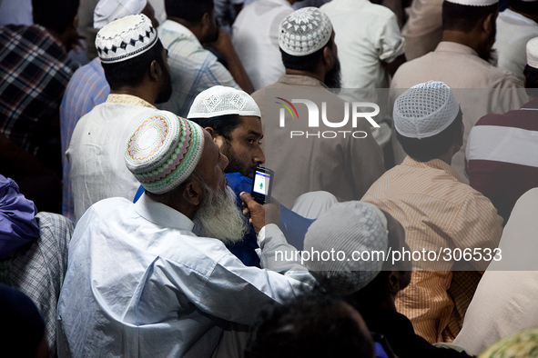An old man was recording the speech of imams so that he listen to that afterwards. 
