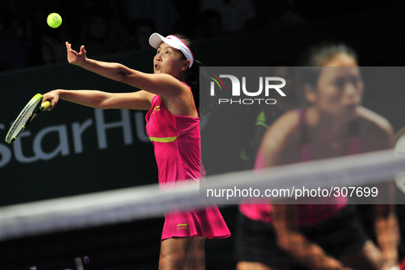 (141026) -- SINGAPORE, Oct. 26, 2014 () -- Peng Shuai (L) of China serves the ball during the doubles final match of WTA Finals with Hsieh S...
