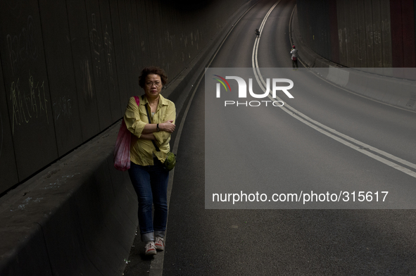 28th of October, 2015. Hong Kong, Hong Kong island, Admiralty. People walk through a car tunnel on the main road in the occupied areas in Ce...