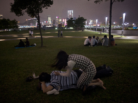 28th of October, 2015. Hong Kong, Hong Kong island, Admiralty. A couple relaxing and giving back massage by Tamar Park, area occupied by the...