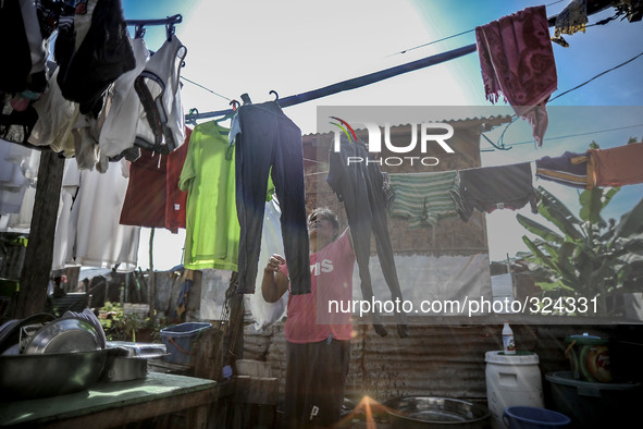 A resident hangs her laundry outside her home at a coastal village one year since Typhoon Haiyan hit in Tacloban, Leyte province, Philippine...