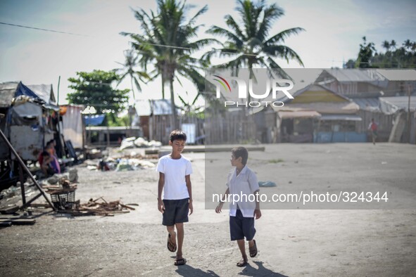 Boys walk along a coastal village one year since Typhoon Haiyan hit in Tacloban, Leyte province, Philippines, November 6, 2014. November 8 w...
