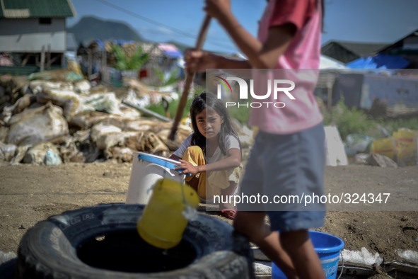 Girls fetch water from a well at a coastal village one year since Typhoon Haiyan hit in Tacloban, Leyte province, Philippines, November 6, 2...